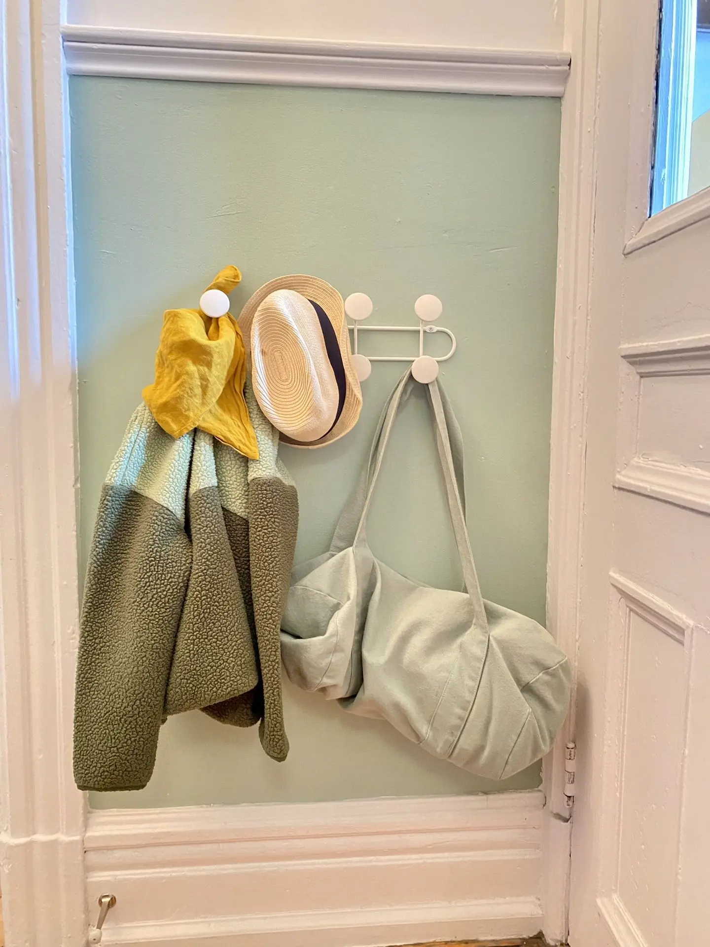 Patère à hauteur d’enfant dans l’entrée, avec manteau, chapeau et sac : aménagement pensé pour l’autonomie quotidienne