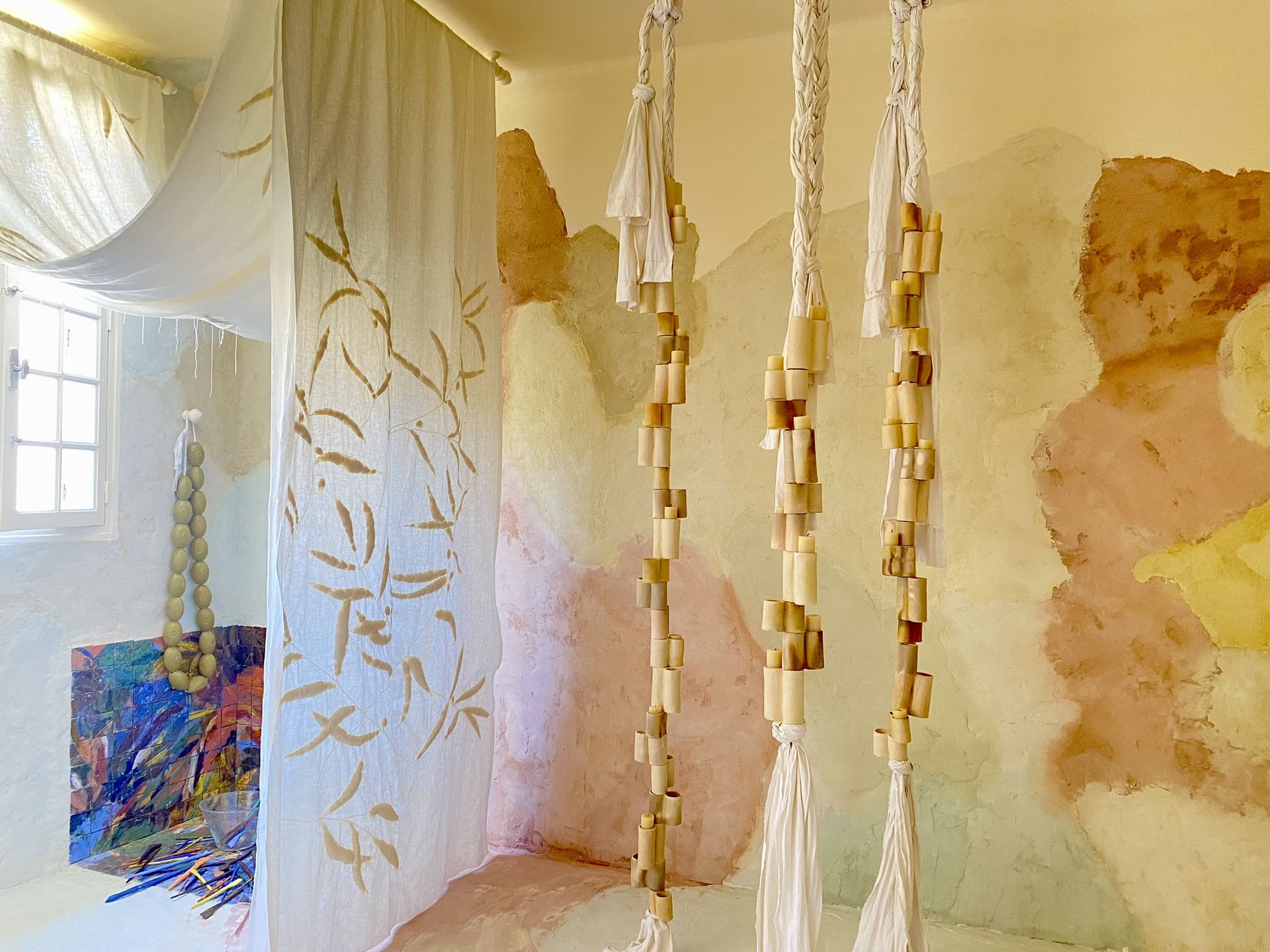 Tenture textile artisanale devant un enduit naturel dégradé aux couleurs terre dans l’ancien évêché de Toulon pour la Design Parade. Post Instagram Studio Pacha.